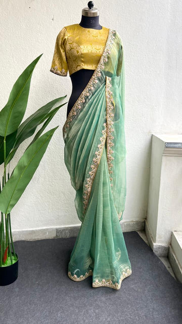 Light green soft tissue saree with golden banarasi blouse