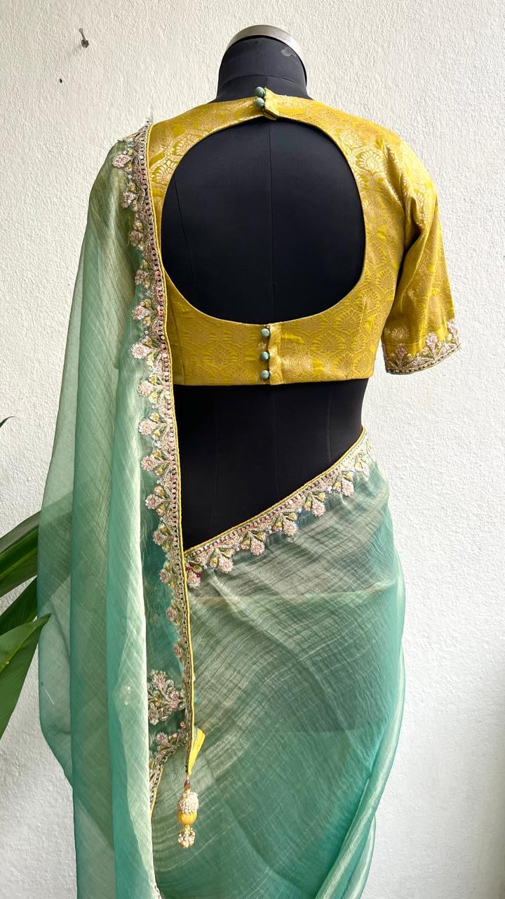 Light green soft tissue saree with golden banarasi blouse