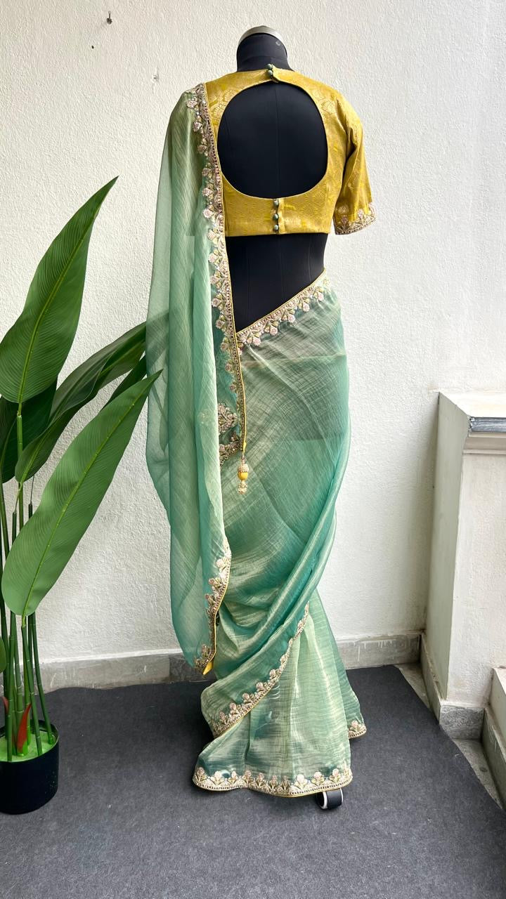Light green soft tissue saree with golden banarasi blouse